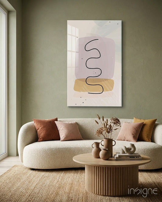 Modern living room with curved cream sofa displaying framed glass wall art featuring lavender and mustard geometric shapes with black squiggle line above wooden coffee table.