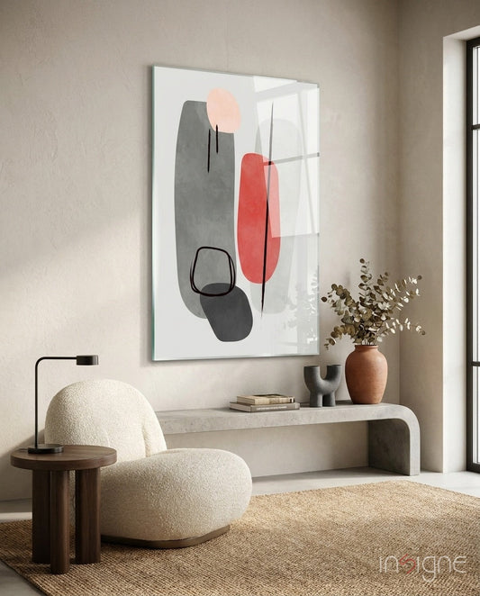 Modern living room interior with abstract framed artwork displaying grey, red, and pink geometric shapes above a curved console table.