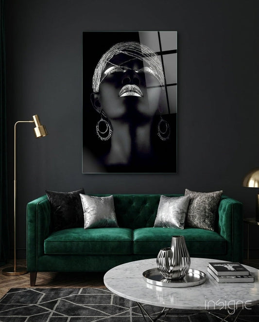 Black and white glass portrait of woman wearing sunglasses and hoop earrings displayed above green velvet sofa.
