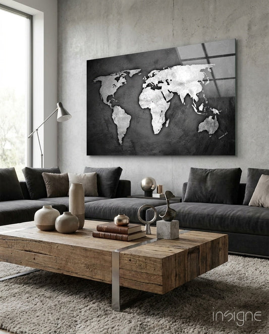 Silver and white world map on dark background displayed above dark gray sofa in modern living room.