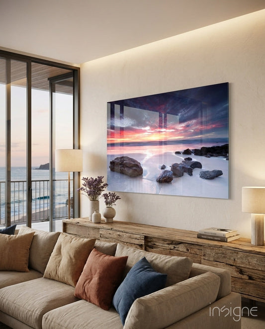 Coastal sunset glass wall art hanging above wooden console in modern beachfront living room with ocean view.