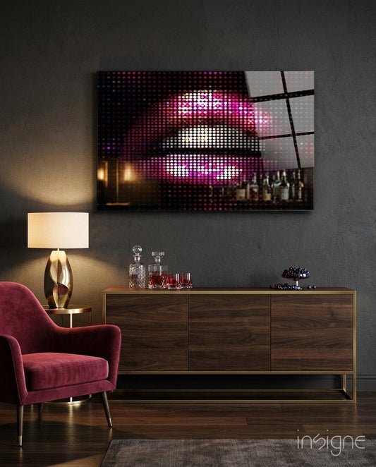 Pink disco dot pixel lips glass wall art displayed above a wooden dresser in a modern living room with burgundy chair and lamp.