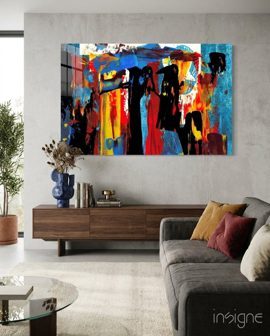 Vibrant abstract glass wall art with red, blue, yellow, and black expressive figures displayed above a wooden console in a modern living room.