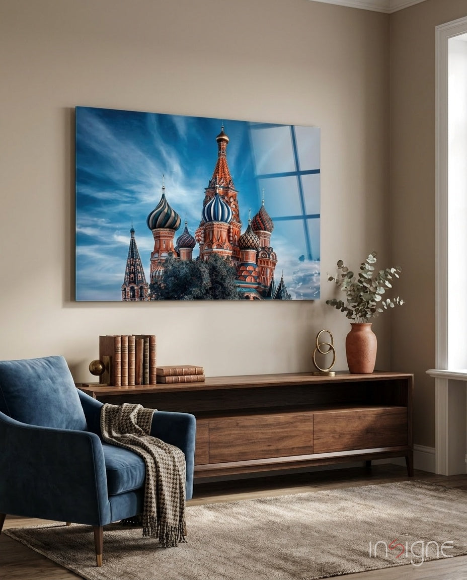 St. Basil's Cathedral glass wall art displayed above wooden dresser in beige room with blue chair.