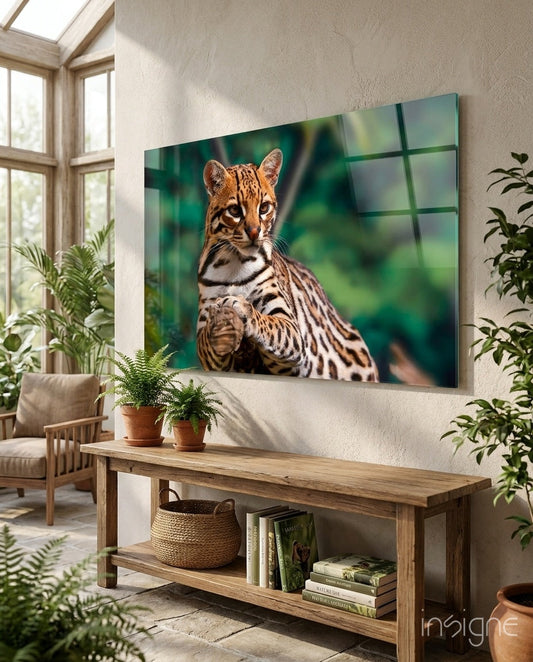 Cheetah glass wall art displaying a spotted wild cat against green blurred background, mounted in bright room with plants and wooden furniture.