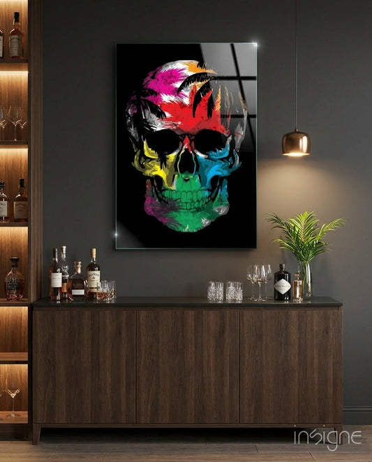 Colorful rainbow feather skull glass wall art displayed above a dark wood bar cabinet with liquor bottles and glassware.