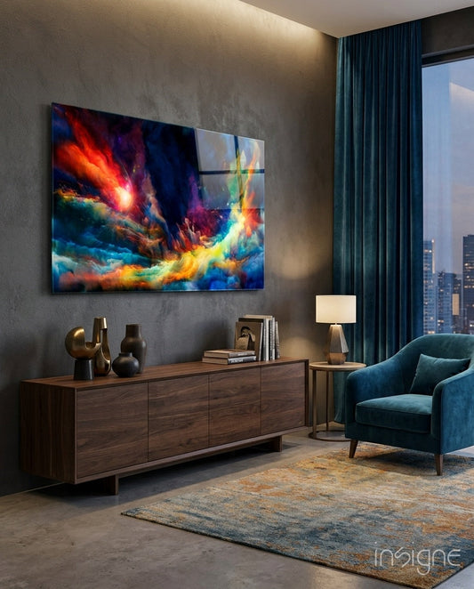 Vibrant multicolored space glass art panel featuring orange, red, blue, and yellow nebula-like clouds displayed on gray wall above wooden dresser in modern apartment interior.