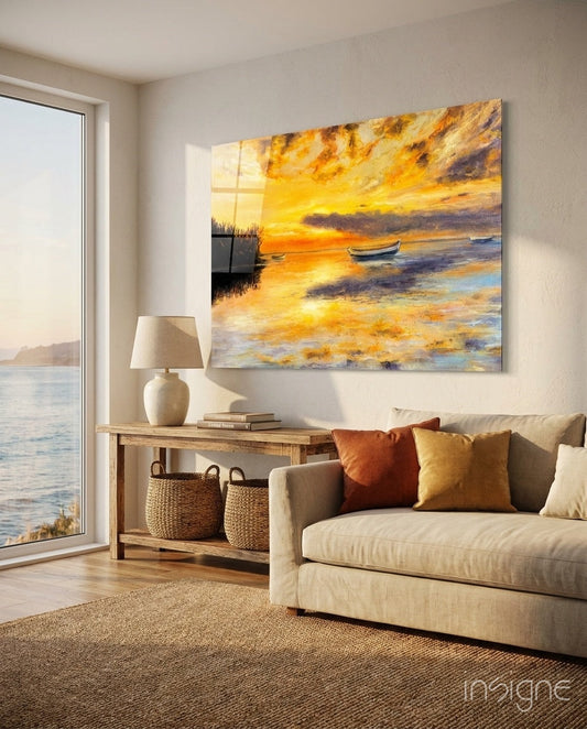 Golden sunset rowboats painting displayed on beige wall above wooden console table in coastal living room with cream sofa and ocean view window.