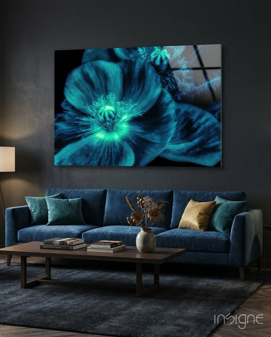 Glowing turquoise poppy artwork displayed on dark wall above blue sofa in modern living room setting.
