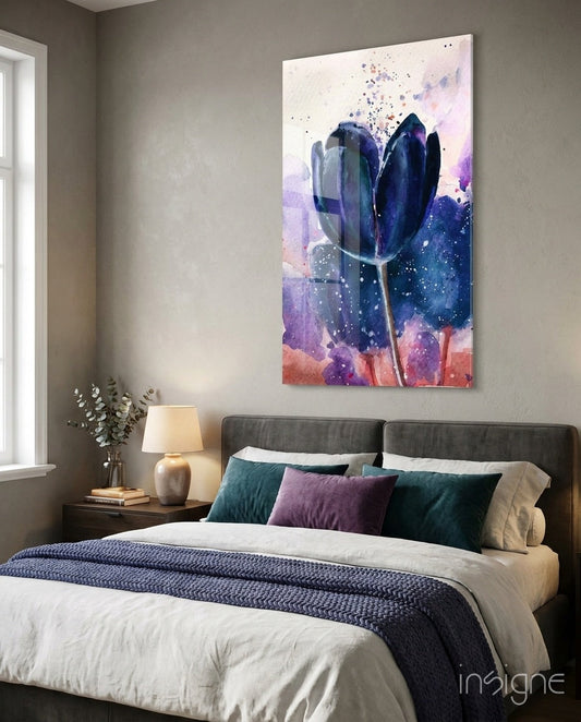 Navy indigo tulip glass wall art hanging above gray upholstered bed with purple and teal pillows in modern bedroom.