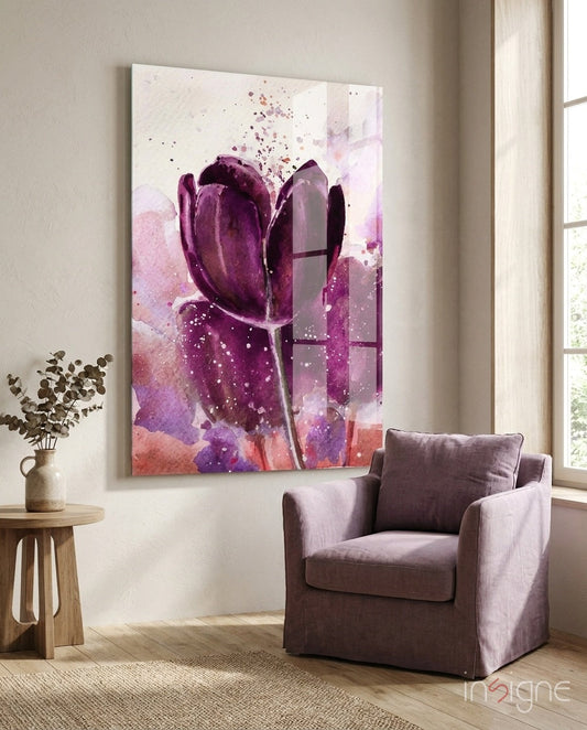 Deep purple watercolor tulip glass wall art displayed above a gray armchair in a bright room with wooden side table and dried flowers.