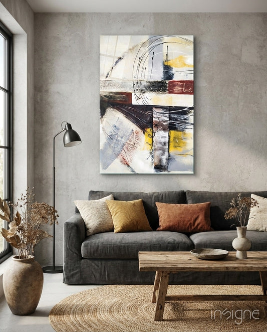 Abstract glass wall art with circular motifs and layered geometric shapes in cream, yellow, red, and black hanging above gray sofa in modern living room.