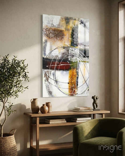Abstract glass wall art featuring layered geometric rings in gold, black, and white tones displayed above a wooden console table in a living room setting.