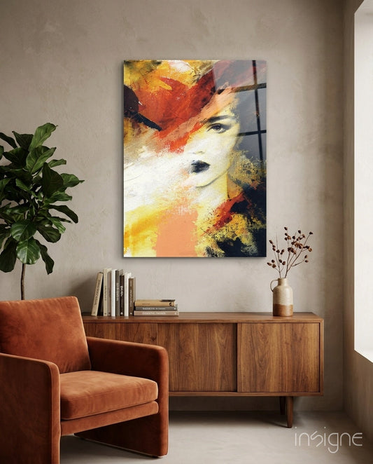 Abstract portrait glass wall art with warm orange, yellow, and red tones displayed above wooden sideboard in modern living room.
