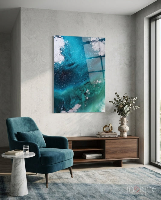 Deep teal and turquoise abstract wave glass wall art hanging above wooden media console in modern living room setting.