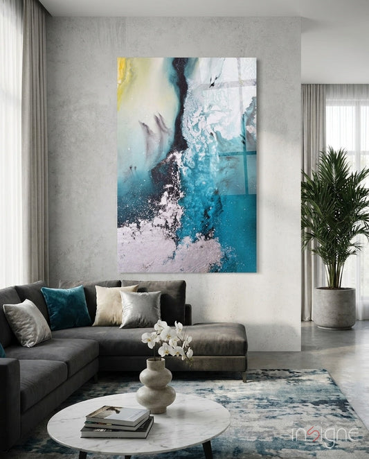 Teal Yellow Ink Cascade Glass Wall Art hanging above a gray sectional sofa in a modern living room with concrete walls.