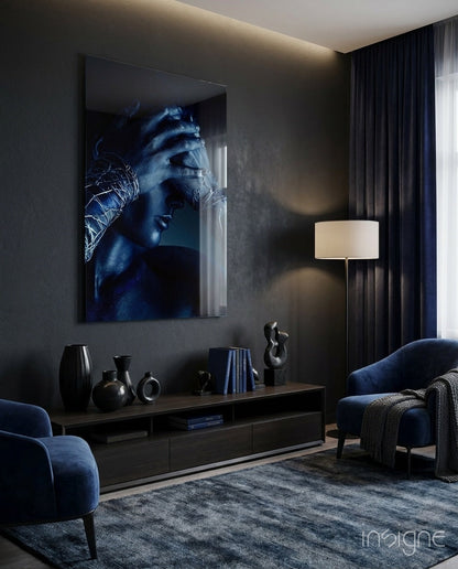 Deep Thought Glass Wall Art displaying a blue-toned portrait of a contemplative face mounted above a dark console table in a modern living room.