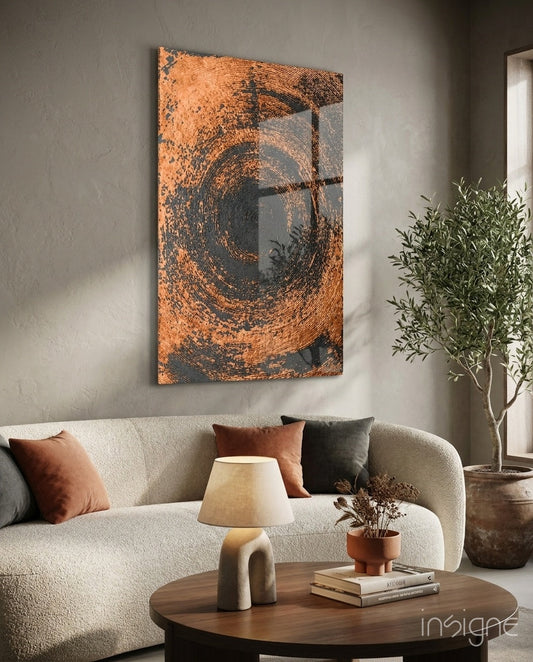 Copper Spiral Swirl Glass Wall Art displayed above a cream curved sofa in a minimalist living room setting with warm lighting.