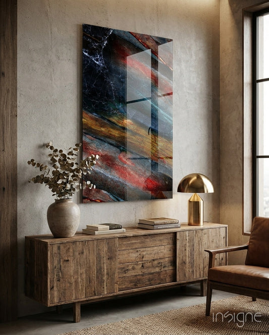 Abstract glass wall art with layered geometric shapes in dark blue, red, gold, and grey tones displayed above wooden sideboard in modern interior.