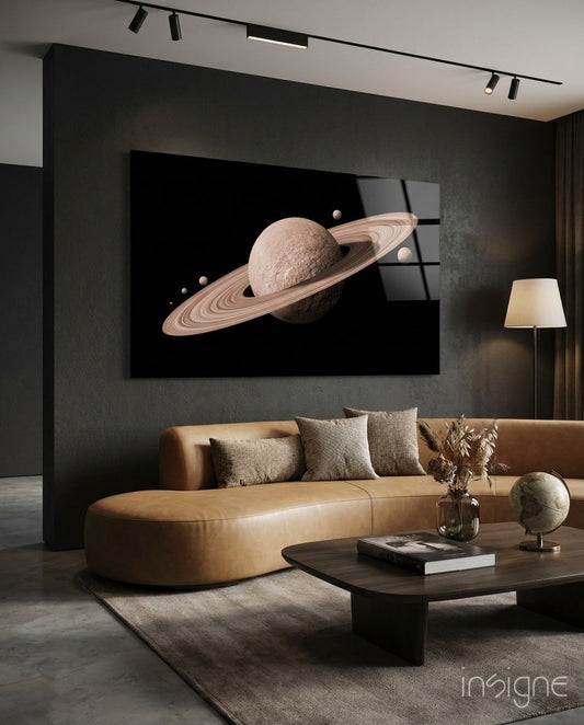 Pale rose ringed planet artwork displayed on dark wall above tan leather sofa in modern living room interior.