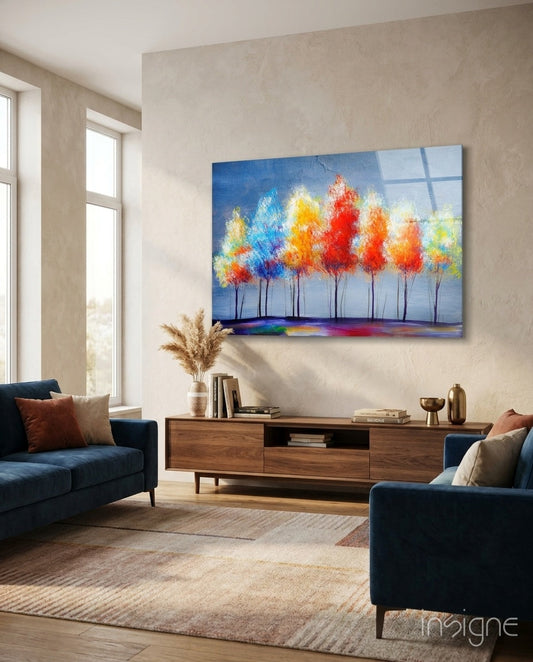 Colorful tree glass wall art displaying vibrant red, orange, yellow, and blue foliage hung above wooden TV console in modern living room.
