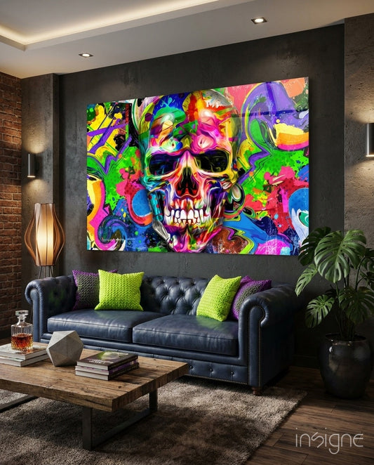 Vibrant neon graffiti skull glass wall art displayed above black leather sofa in modern living room setting.