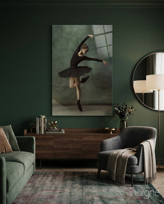 Black tutu ballerina glass wall art displayed above wooden dresser in sage green living room interior.