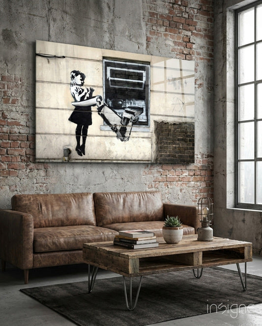 Industrial loft interior with brown leather sofa, wooden table, and black-and-white stencil street art on concrete wall.