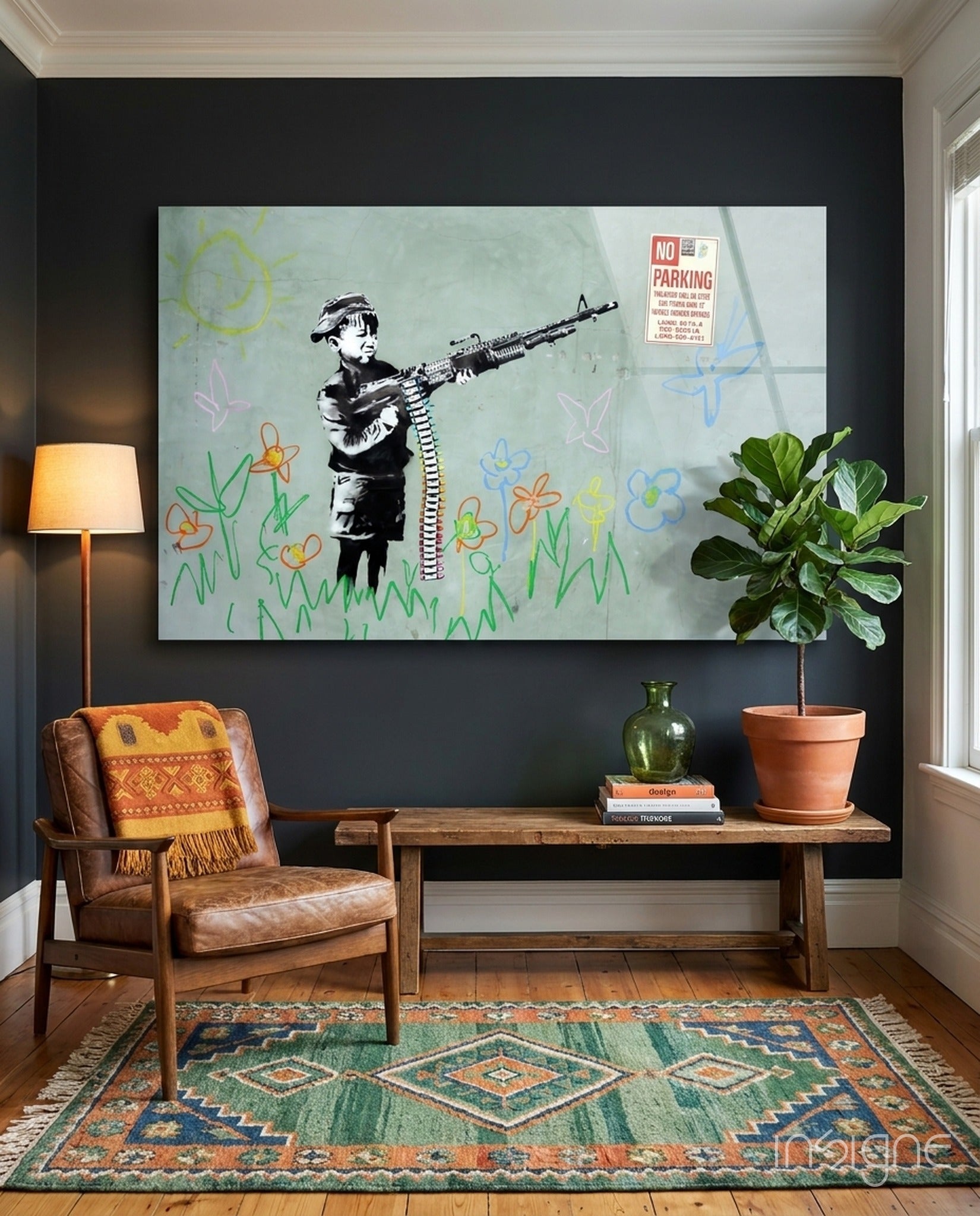 Black and white stenciled child figure holding rifle with colorful childlike drawings displayed on dark wall above wooden bench.