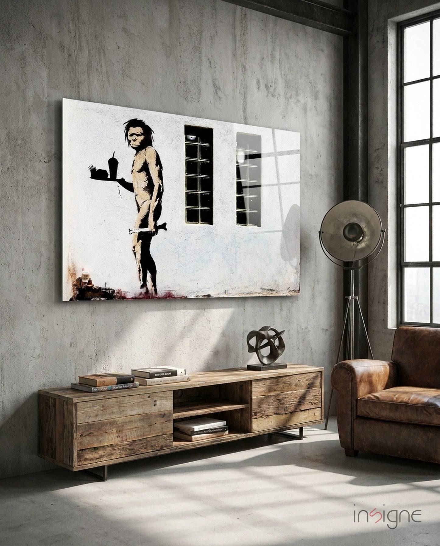 Neanderthal Glass Art canvas hanging on concrete wall above wooden media console in industrial loft interior with leather chair.