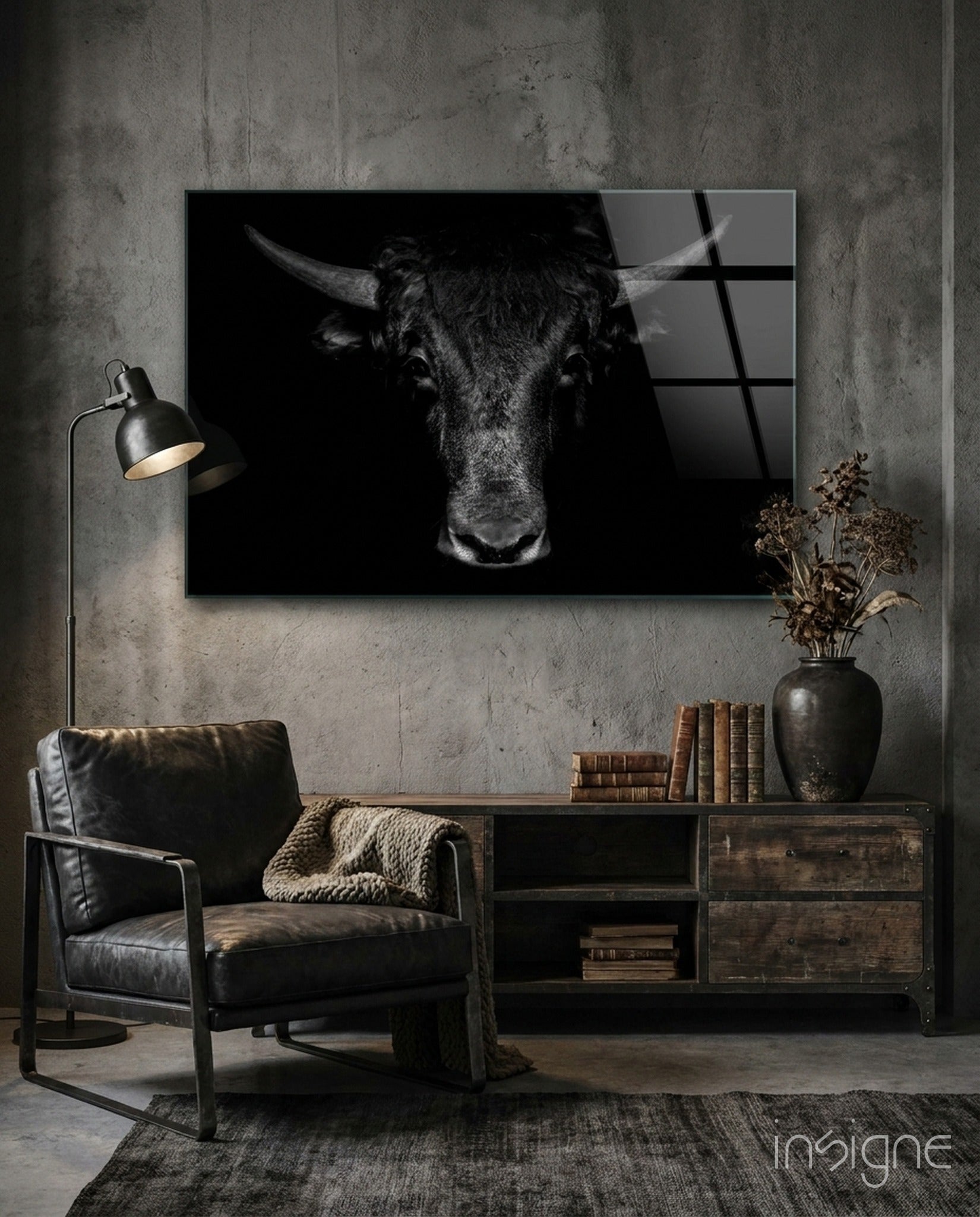Black and white buffalo portrait glass art displayed on concrete wall above wooden shelving in industrial-style room setting.