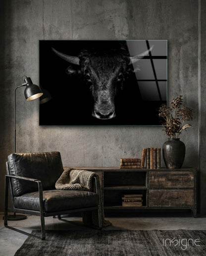 Black and white buffalo portrait glass art displayed on concrete wall above wooden shelving in industrial-style room setting.
