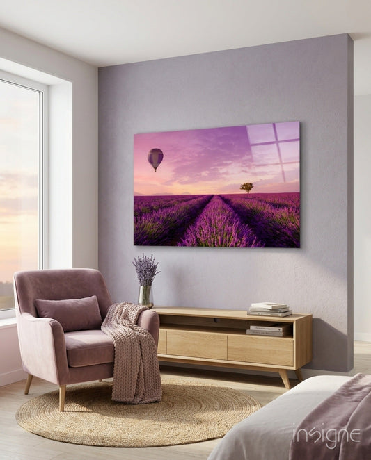 Glass art print of purple lavender field with hot air balloon and tree at sunset, displayed on bedroom wall above wooden console table.