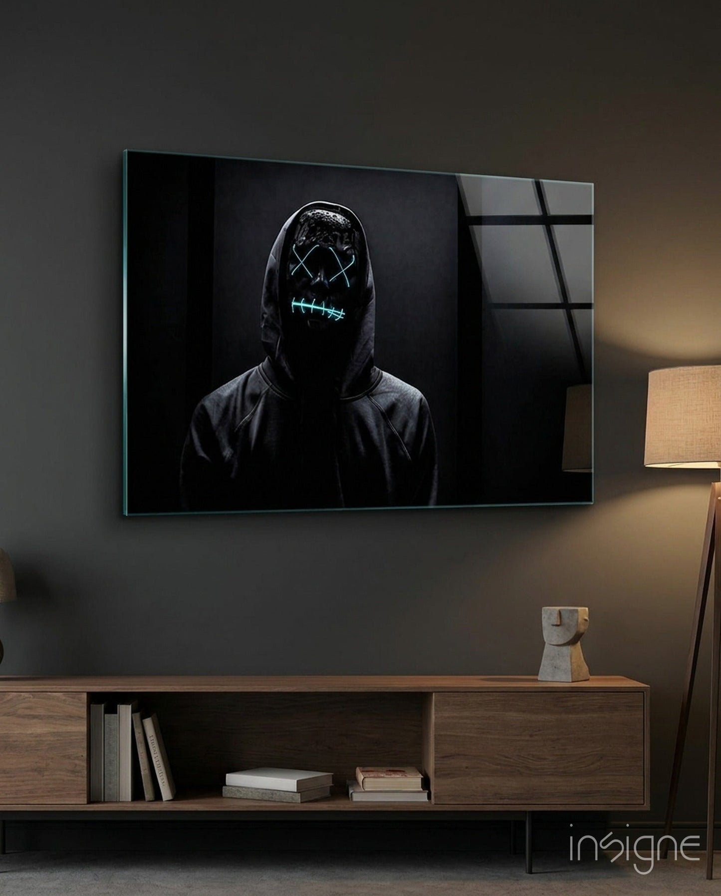 Wall-mounted TV displaying neon mask artwork above wooden media console in modern interior setting with lamp.