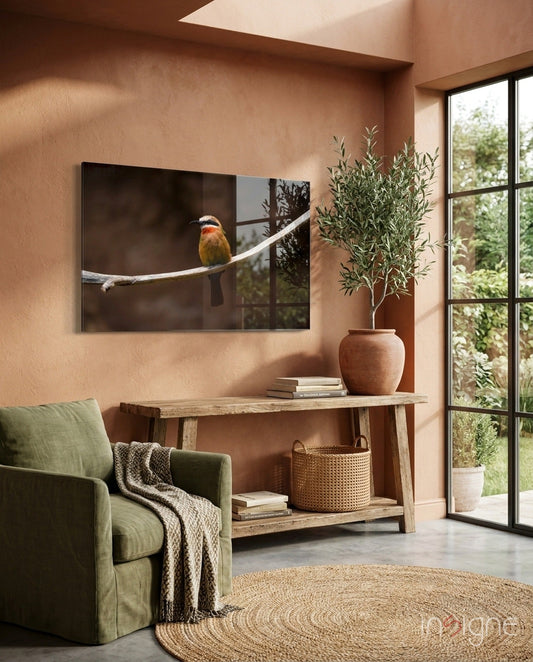 Bee Eater glass art displaying a colorful bird perched on a branch, mounted on a terracotta wall above a wooden console table in a living room setting.
