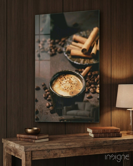 Glass art print of steaming coffee cup with cinnamon sticks and beans displayed on wooden wall above desk.