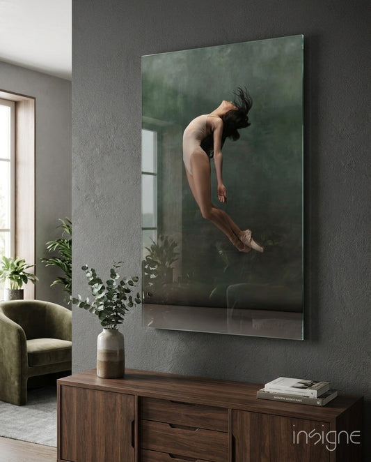 Glass wall art depicting a woman in mid-leap pose displayed above wooden console table in modern interior setting.