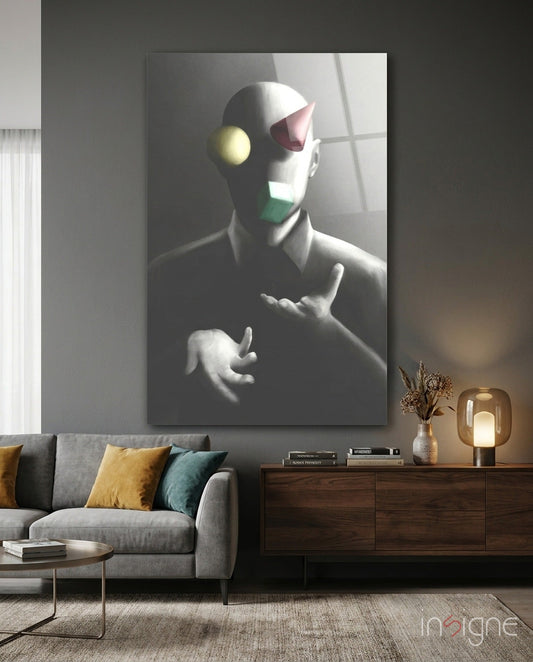Abstract glass wall art depicting a stylized figure with colored geometric shapes mounted above a gray sofa in a modern living room.
