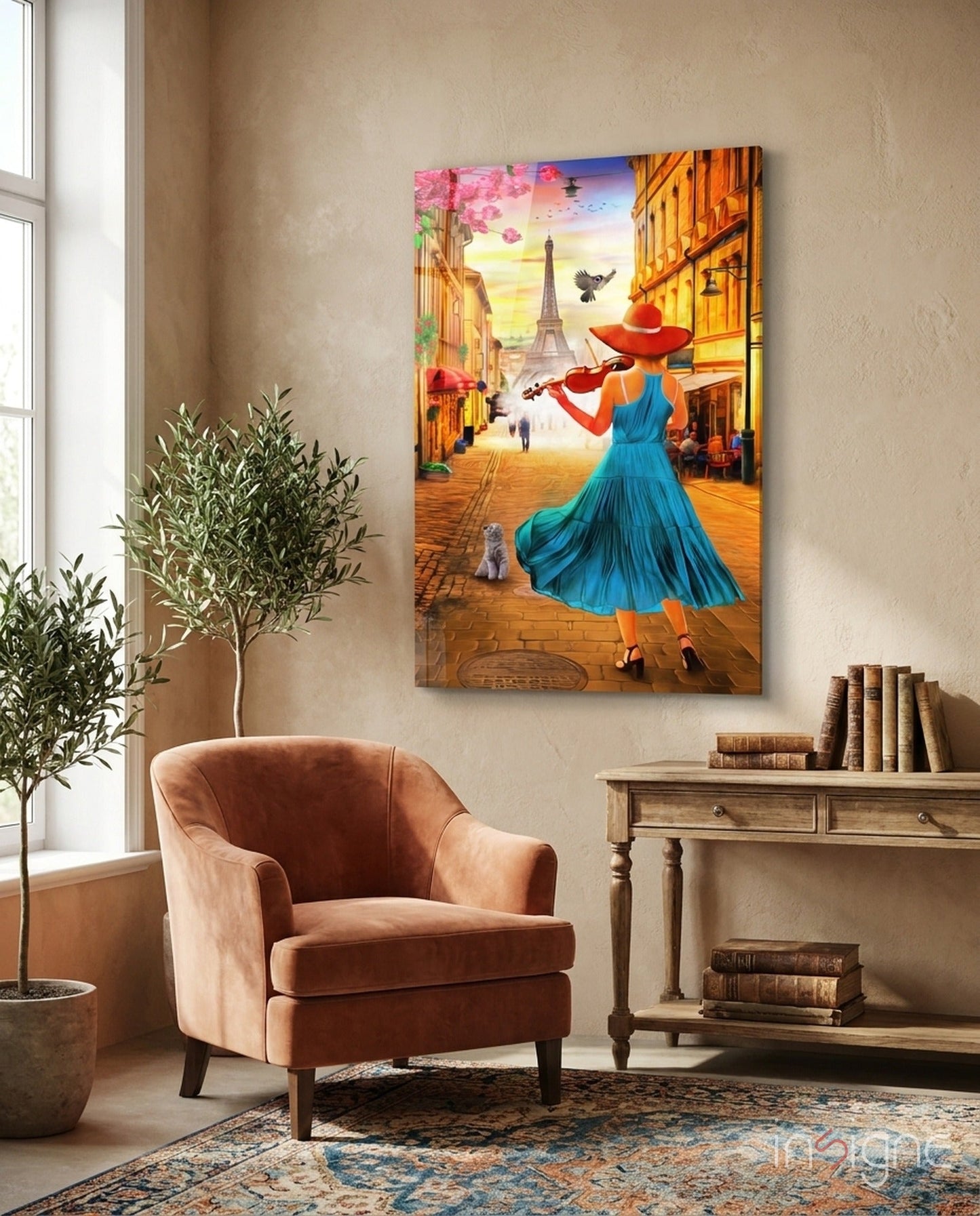 Colorful glass wall art depicting a woman in blue dress playing violin on a Paris street with Eiffel Tower, displayed above a terracotta armchair in a home interior.