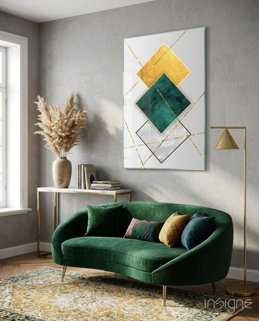 Modern living room interior displaying gold and emerald diamond geometry glass wall art above green velvet sofa with decorative pillows.