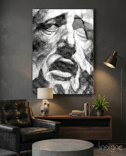 Black and white wavy line pattern glass wall art displayed above wooden desk in modern interior setting with leather chair and lamp.