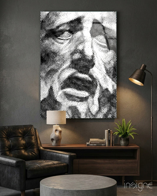 Black and white wavy line pattern glass wall art displayed above wooden desk in modern interior setting with leather chair and lamp.