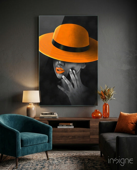 Orange Hat Glass Wall Art displayed above wooden console table in modern living room with teal chair and orange accessories.