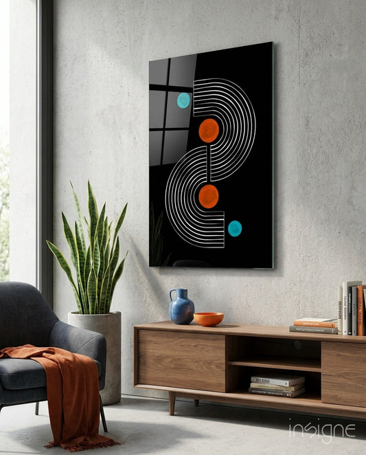 Black glass wall art with white geometric S-curves and orange and cyan dots displayed above wooden console in modern living room setting.