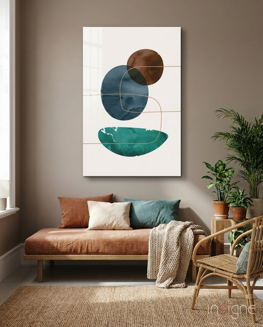 Abstract glass wall art with teal bowl, navy circle, and brown circle on cream background, displayed above cognac leather daybed in styled living room.