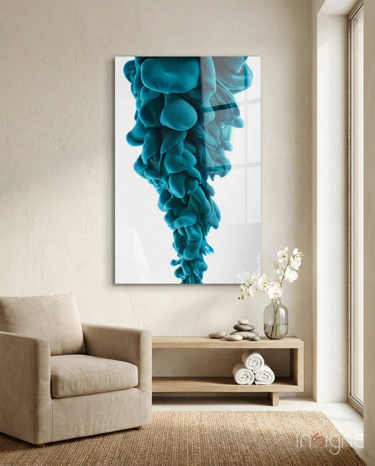 Blue layered glass wall art depicting cascading turquoise ink clouds displayed above wooden shelf in minimalist room setting.