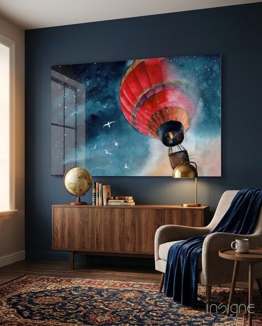 Red and gold hot air balloon floating through starry blue sky displayed on dark blue wall above wooden dresser in modern living room.