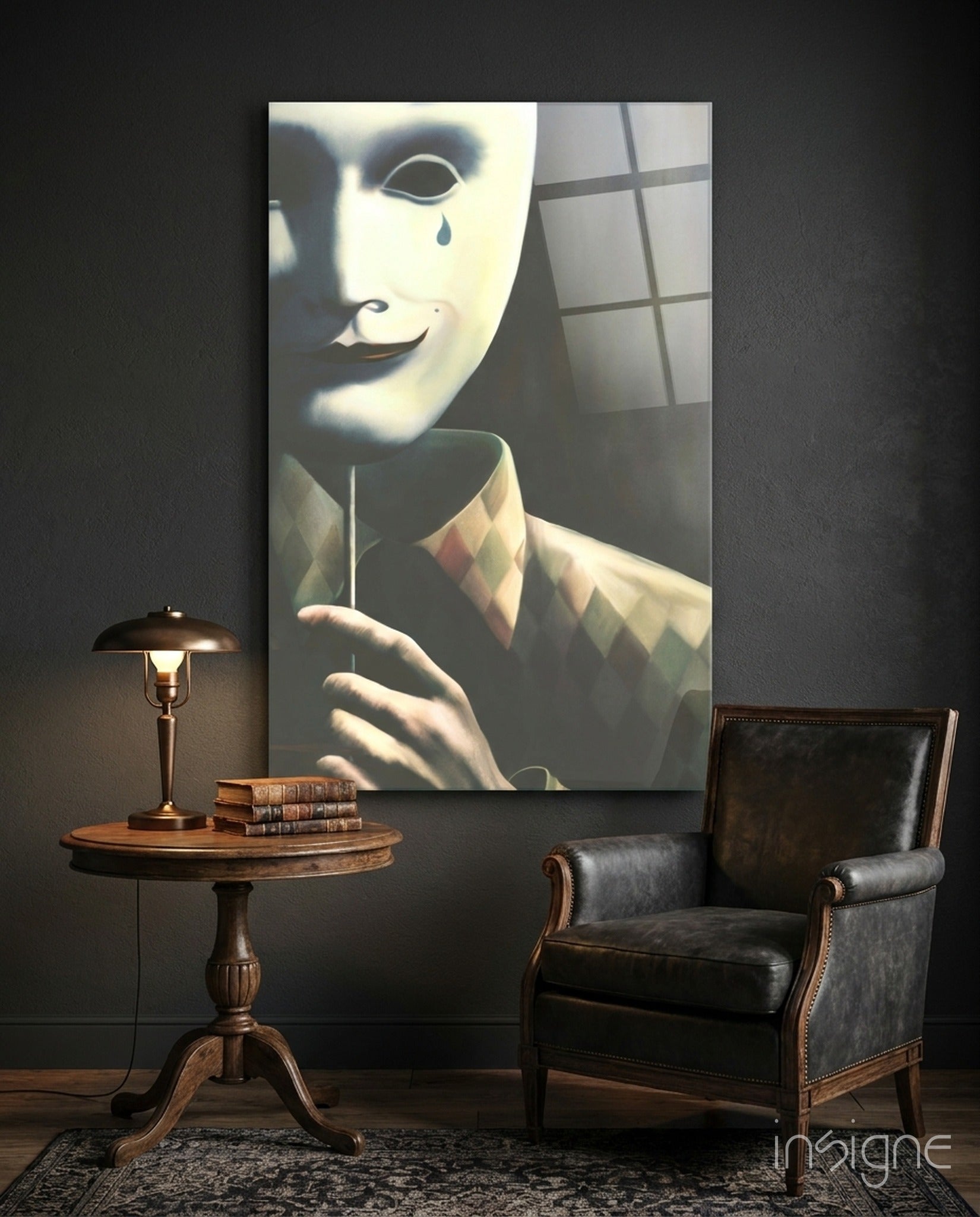 Glass wall art depicting a pale masked figure in a checkered shirt with a single tear, displayed above a wooden table and leather chair in a dark interior setting.