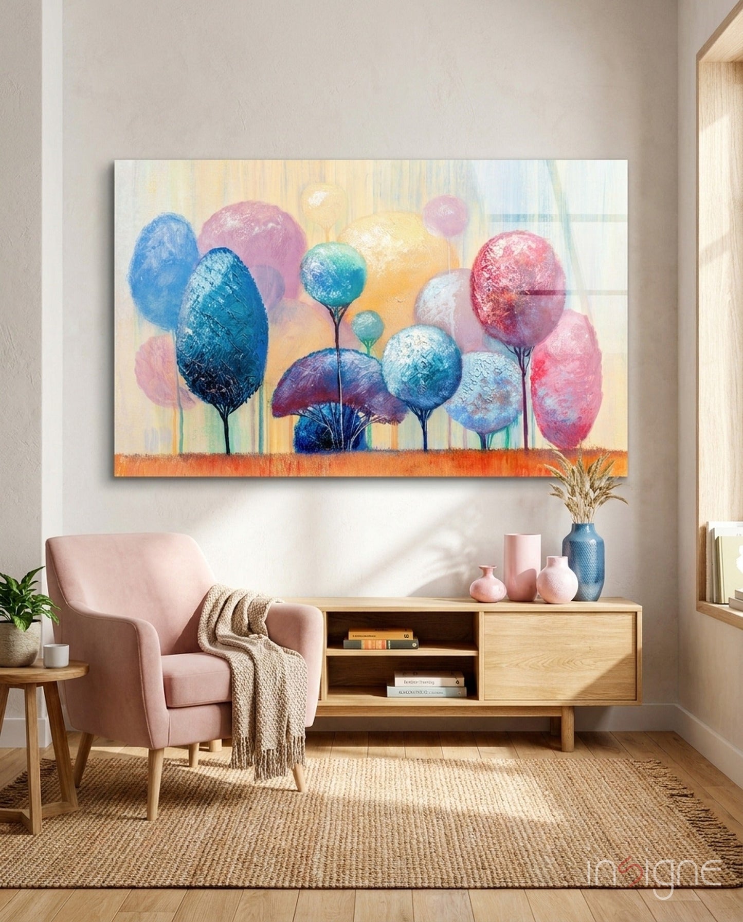 Colorful abstract trees glass wall art hanging above wooden sideboard in minimalist living room with pink armchair.