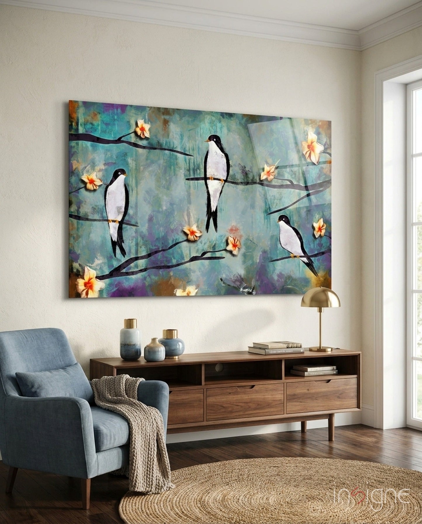 Glass wall art depicting black and white birds perched on branches with yellow flowers against a turquoise, purple, and gold textured background, displayed above a wooden console table in a living room.